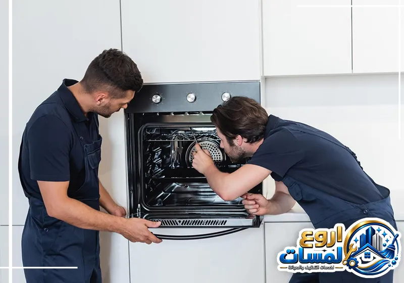 فني صيانة يفحص باب الفرن والمكونات الداخلية للتأكد من جودة العزل وسلامة الاستخدام بعد الإصلاح.