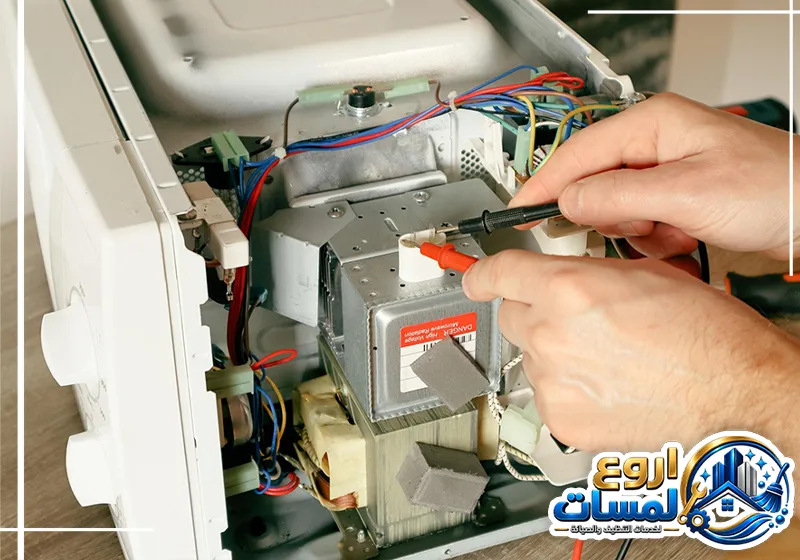فني شركة تصليح ميكروويف بالرياض 0510743232 شركة اروع لمسات فني يقوم بفحص المكونات الداخلية للميكروويف باستخدام أدوات متخصصة لتحديد العطل الصيانة للجهاز.